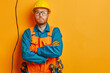 Construction worker with tools on yellow background