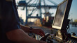 Close-up: Officer checks cargo metrics on computer at the port.