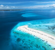 Aerial view of Nakupenda island, sandbank in ocean, white sandy beach, boats, yachts, blue sea during low tide at sunny summer day in Zanzibar. Top view of sand spit, clear water, sky. Tropical