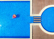 Aerial view of young woman on swimming ring in pool in summer