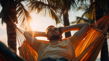 A person lying in a hammock strung between two palm trees, eyes closed and face relaxed with happiness.