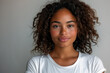 © Spicy World - Black female model in a minimalist white shirt, close-up portrait against plain white background