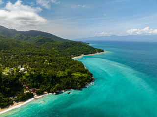 Waves on coastline under blue sky and clouds. Samal Island. Davao, Philippines.