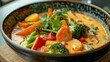 © Pixel Skull Design - A close-up image of a bowl of vegetable curry, featuring vibrant broccoli, carrots, and peppers.