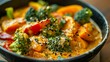 © Pixel Skull Design - A close-up image of a bowl filled with vibrant vegetable curry, featuring broccoli, carrots, and peppers.