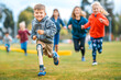 © MVProductions - Smiling little boy with prosthetic leg running on field with his friends