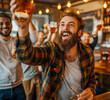 © MVProductions - Young people with beer in hands cheer football game together at bar