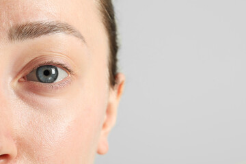 Wall Mural - Closeup photo of woman with beautiful eyes on light background. Space for text