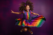 © mohsin - A little girl with curly hair and a happy expression, wearing a rainbow-colored skirt, jumping against a vibrant purple backdrop.