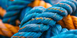 Orange and blue rope tied around another rope.