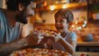 A father and son are eating pizza together. The father is smiling and holding the pizza while the son is taking a bite.