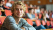 © Keitma - Portrait of a blond hair nordic caucasian happy university student sitting in a college lecture hall