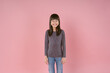 Cute smiling Asian girl feel happy laugh at funny joke and looking at camera in isolated studio light pink color background