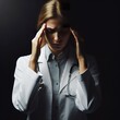 An woman doctor portrait having a headache, with the rim light. The background is black