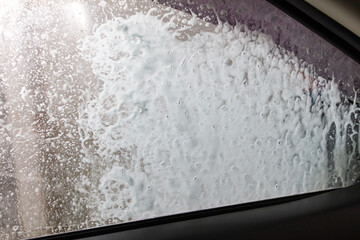 Sticker - Car glass at a car wash In drops of water. Background