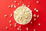 Fototapeta Boho - Home cinema experience with TV app. Top view of popcorn in bowl. Red background with space for text or advertising