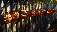 Pumpkins Carved With Sinister Faces Lining A Wooden Fence, Casting Ominous Shadows