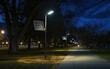 Solar-powered lights line a park path at dusk offering a sustainable glow