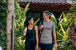 © Maskot - Smiling mature couple walking amidst plants at wellness resort
