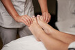 © Oksana - Massage therapist doing foot and leg massage with hands