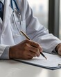© dip - A doctor is writing in their paper with a pen on desk