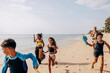 © Maskot - Happy children running with father and mother on sand near beach