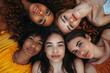 A group of beautiful diverse women lying on the ground with their heads together looking up
