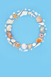Sea shell abstract wreath on pastel blue background. Large collection of exotic and tropical shells, natural  summer nature design.