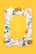 Exotic seashell background border with assorted shells on yellow background with white frame. Minimal natural nature sea life design.
