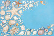 Seashells and pearls background border on rustic mottled blue. Natural nature design with large collection of shells.