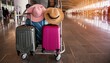 Colorful suitcases and hat placed on trolley in modern airport terminal before flight during trip