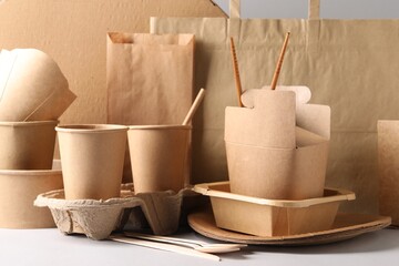 Wall Mural - Eco friendly food packaging. Paper containers, tableware and bag on white table