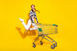 Full length photo of excited cheerful woman wear cow skin print top jumping enjoying shopping isolated yellow color background