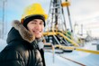© senyumanmu - Smiling young engineer wearing hardhat at oil production field in winter