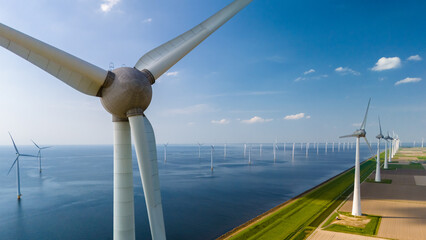 Wall Mural - Aerial view of windmill turbines spinning gracefully in a wind farm near the ocean in the Netherlands Flevoland