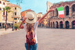 Rear view of woman holding Italian flag in Verna city- Travel destination, tour tourism in Italy, Europe