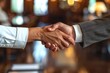 © Vilaysack - A close-up of a handshake between diverse business partners in an elegant boardroom, a signed contract on the table, symbolizing a successful deal