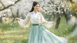 © Anastasiia - Graceful Young Woman in Traditional Dress Among Cherry Blossoms