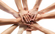 Closeup view of people stacking their hands together for unity and teamwork on white background