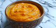Close-up of a spoonful of mashed carrots highlighting the smoothness and vibrant color of early stage baby food.