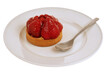Tartelette aux fraises dans une assiette avec une cuillère en gros plan sur fond blanc