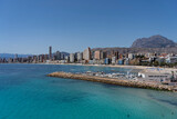 Fototapeta  - Panorama of Benidorm including the breakwater, small marina, local beach and the majestic Puig Campana mountain in the background.