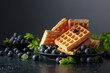 Belgian waffles with fresh blueberries on a black plate.