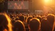 A large crowd of people gathered outdoors, watching a movie on a huge screen.