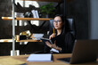 © Andrii Zastrozhnov - A successful young Asian businesswoman in her office, thinking and working on her computer.