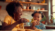 © Creative mind - Happy grandmother and granddaughter eating cookies in the kitchen.