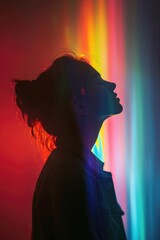 Poster - A person's silhouette with a rainbow light in the background, suitable for various design projects
