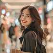 young charming woman looking with smile in shopping mall and with bags, smiling