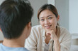 © polack - Family psychologist Asian woman talking to a client in private clinic. Asian couple at home sitting in sofa and having a talk