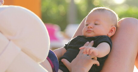 Wall Mural - Baby close-up at the poolside with mom